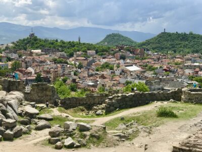 Ciew of Plovdiv city from the ancient ruins, with hills in the background and buildings spread across the valley.