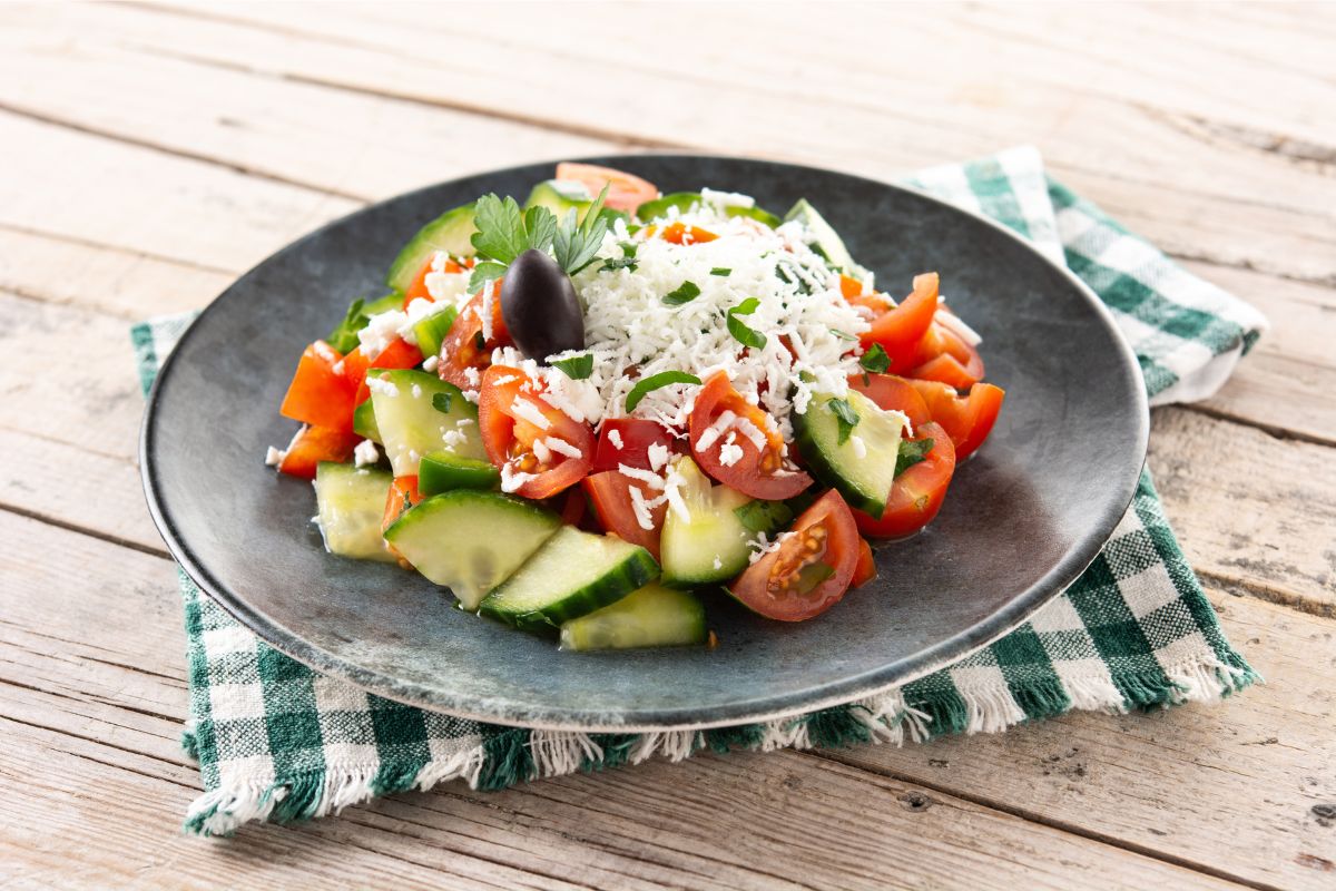 Shopska salad - traditional Bulgarian salad with cucumbers, tomatoes, onion, and white cheese.