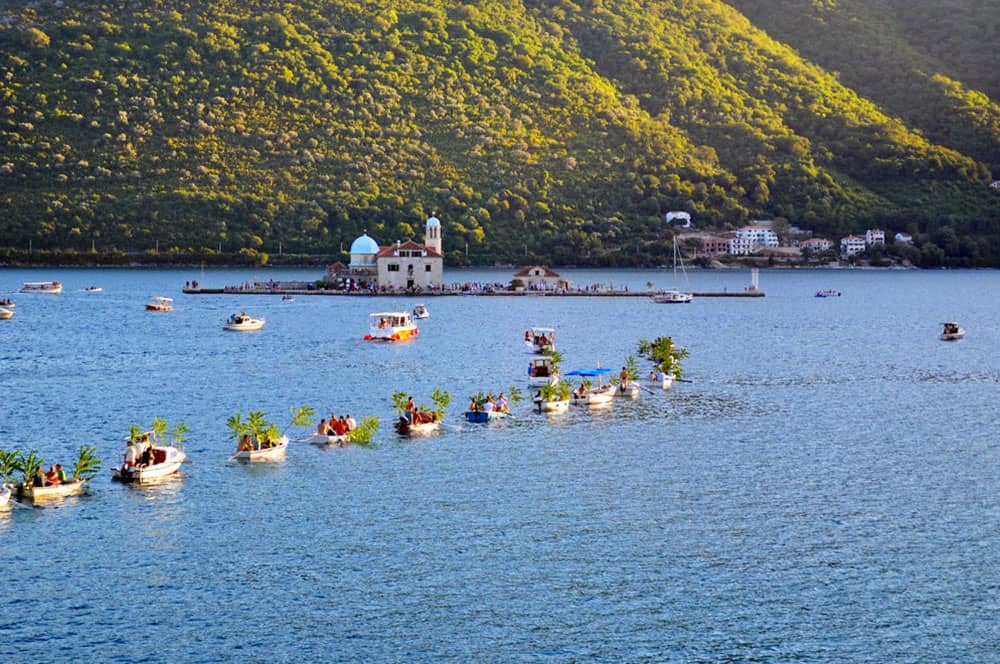 A flotilla of rowboats decorated with flowers during the Fašinada Boat Procession in Montenegro